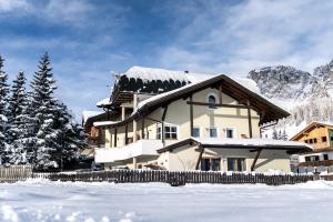 a house with a snow covered roof in the snow at dalaNat in Corvara in Badia
