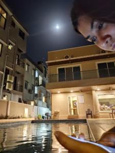 a woman is looking at a swimming pool at night at Fortune Resort in Nagaon