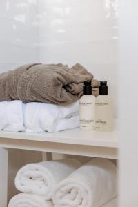 a shelf with towels and two bottles of shampoo at B&B Buytenlust in Rockanje