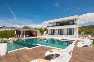 eine Villa mit Swimmingpool und ein Haus in der Unterkunft Luxury Villa Arya with 77sqm heated pool, hot-tub, sauna, gym, billiard, playgrounds, 6 bedroom in Bajagić