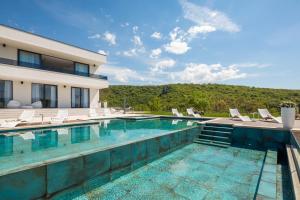 ein Schwimmbad vor einem Gebäude in der Unterkunft Luxury Villa Arya with 77sqm heated pool, hot-tub, sauna, gym, billiard, playgrounds, 6 bedroom in Bajagić + 42 Fotos
