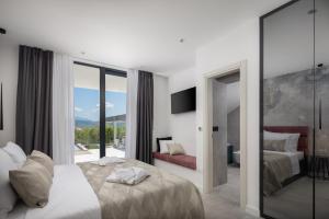 una camera da letto con due letti e una grande finestra di Luxury Villa Arya with 77sqm heated pool, hot-tub, sauna, gym, billiard, playgrounds, 6 bedroom a Bajagić Altre 42 foto