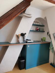 een keuken onder de trap met een blauwe kast bij Dachstudio Herkulesblick in Kassel