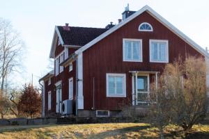 una casa roja con un adorno blanco en Kurrebo Vandrarhem en Urshult