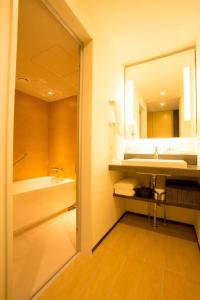 a bathroom with a sink and a mirror at JR Kyushu Hotel Blossom Shinjuku in Tokyo