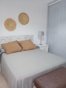 ein weißes Bett mit zwei Kissen darüber in der Unterkunft VACATIONAL HOMES South Organic in Málaga