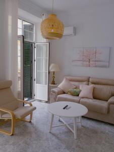 ein Wohnzimmer mit einem Sofa und einem Tisch in der Unterkunft VACATIONAL HOMES South Organic in Málaga