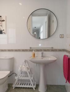 ein Bad mit einem Waschbecken und einem Spiegel in der Unterkunft VACATIONAL HOMES South Organic in Málaga