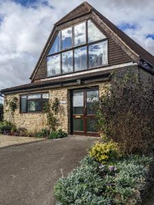 a brick house with windows and flowers in front of it at Kingfisher Barn in Abingdon
