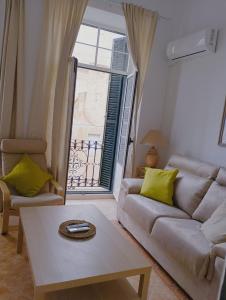 ein Wohnzimmer mit einem Sofa, einem Tisch und einem Fenster in der Unterkunft VACATIONAL HOMES South Organic in Málaga