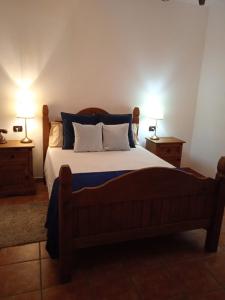 a bedroom with a bed with two lamps on two tables at Jaye’s Home in Arona