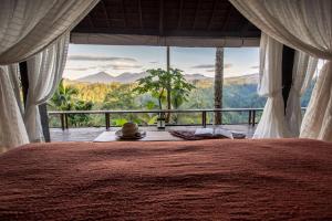 a bedroom with a bed with a view of the mountains at Buahan, a Banyan Tree Escape in Payangan