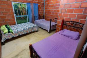 a room with two beds and a brick wall at LAS ORQUIDEAS in Rozo +21 photos