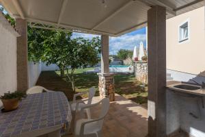 un patio con mesa, sillas y fregadero en Natur, en Šegotići
