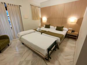 A bed or beds in a room at Hotel Boutique Convento Cádiz