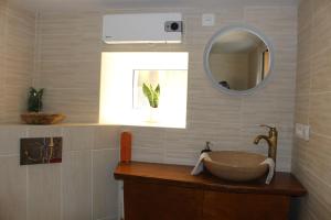y baño con lavabo y espejo. en Petite maison chaleureuse avec jacuzzi privatif, en Savigny-sous-Mâlain