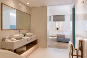 ein Badezimmer mit Waschbecken und Spiegel in der Unterkunft Avra Apartments Venetian Harbour in Chania + 71 Fotos