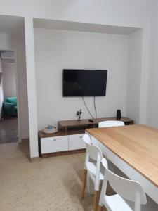 a living room with a table and a flat screen tv at Departamento céntrico por día in Bahía Blanca