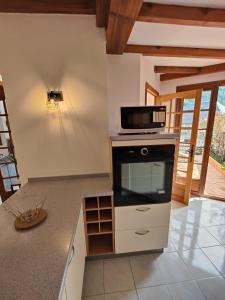 a kitchen with a stove and a microwave at gite boutx 10 personnes in Boutx