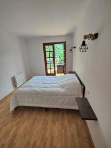 1 dormitorio con 1 cama grande y suelo de madera en gite boutx 10 personnes, en Boutx