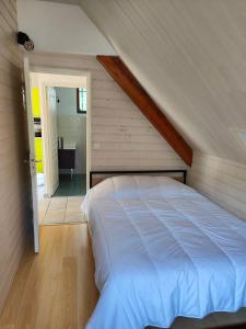 a bedroom with a white bed in a attic at gite boutx 10 personnes in Boutx