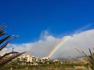 un arco iris en el cielo con casas y palmeras en Penthouse Alcalá 1, en Alcalá