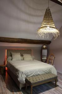 1 dormitorio con cama y lámpara de araña en Petite maison chaleureuse avec jacuzzi privatif, en Savigny-sous-Mâlain
