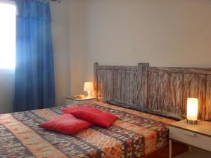 1 dormitorio con 1 cama con 2 almohadas rojas en Penthouse Alcalá 1, en Alcalá