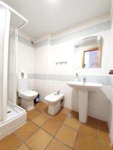 a white bathroom with a sink and a toilet at Maribel ERB Alojamientos in Sierra Nevada