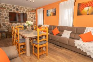 sala de estar con sofá, mesa y sillas en La Casona de Trescasas, en Sonsoto