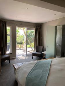 a bedroom with a bed and a view of a patio at Bloemenzee Boutique B&B in Gordonʼs Bay
