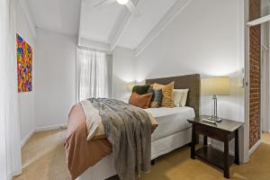 a bedroom with a bed and a table with a lamp at The Reserve Barossa in Nuriootpa