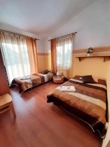 a bedroom with two beds and two windows at Rendas in Cēsis