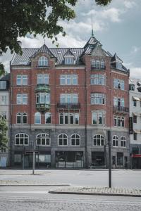 a large red brick building with a pointed roof at Apartments by Brøchner Hotels in Copenhagen