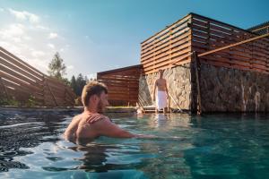 a man in a swimming pool next to a woman at Wellness Hotel Frymburk in Frymburk