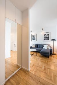 ein Wohnzimmer mit einem Sofa und einem Spiegel in der Unterkunft Apartament Lekka in Warschau