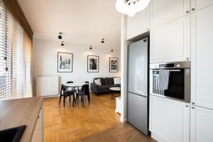 een keuken en een woonkamer met een bank en een tafel bij Apartament Lekka in Warschau