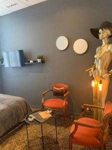a room with a mannequin and two chairs and a bed at L'Appart d'Hugo in Chambéry