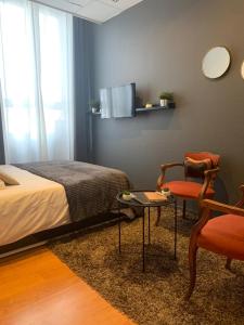 a bedroom with a bed and a table and a chair at L'Appart d'Hugo in Chambéry