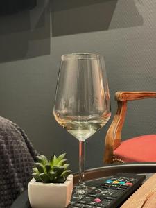 a glass of wine sitting next to a remote control at L'Appart d'Hugo in Chambéry +11 photos