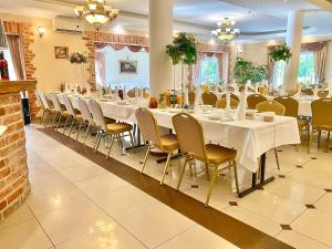 a dining room with white tables and chairs at Ośrodek Wypoczynkowy WULPINK in Majdy