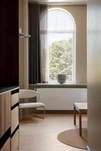 a room with a window and a chair and a table at Apartments by Brøchner Hotels in Copenhagen