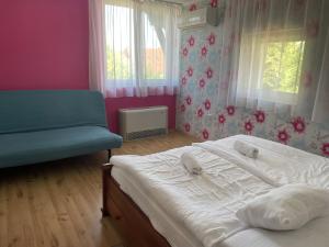 イナールチにあるBagolyvár Inárcsのベッドルーム1室(ベッド1台、ソファ、窓付)