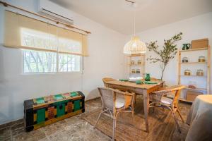 comedor con mesa, sillas y ventana en Villa Viñedo - Agradable Villa Rústica con Jardín, en Sotillo de las Palomas