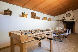 una gran mesa de futbolín de madera en una habitación en Villa Viñedo - Agradable Villa Rústica con Jardín, en Sotillo de las Palomas