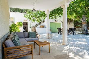 un patio con sofá y mesa en Villa Viñedo - Agradable Villa Rústica con Jardín, en Sotillo de las Palomas
