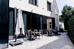 a patio with a table and chairs and an umbrella at Grand Ascot Hotel in Krakow