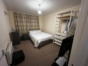 Your Home away from home in Leeds - on the Ring Rd في ليدز: غرفة نوم صغيرة بها سرير وسلم
