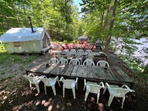 a group of chairs and a table and a tent at Tentrr Signature Site - River's Edge on the Canal in Pond Eddy