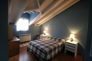 1 dormitorio con 1 cama y 2 mesitas de noche con lámparas en La Casa de Gene en Ruilobuca